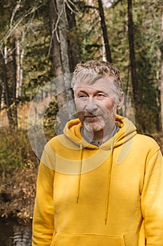 Candid portrait of a beautiful happy middle-aged man outdoors in the forest on a sunny day. Close-up
