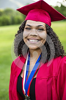 Portrait of a beautiful multiethnic woman in her graduation cap and gown photo