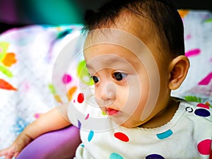 Candid portrait of a cute and expressive Asian baby girl. Lifestyle and childhood concept.