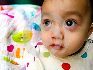 Candid portrait of a cute and expressive Asian baby girl. Lifestyle and childhood concept.