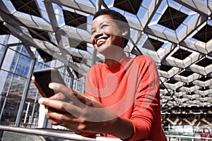 Candid portrait of smiling african american woman holding phone photo