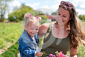 Attractive young woman holding little girl in the countryside