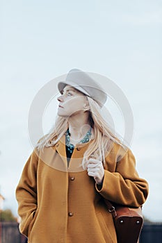 candid portrait of stylish middle aged woman in fashion hat and autumn coat