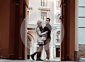 Candid portrait of young man and woman watching to each other on a background of city street. Autumn dating. Love and happiness