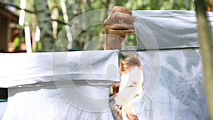 Candid real life portrait of young adult beautiful attractive caucasian woman hanging up fresh washed family clothes on