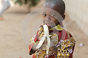 Candid Shot of African Black Boy Eating Banana Outdoor