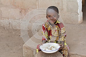 Candid Shot of Little Black African Boy Eating Rice Outdoors