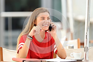 Candid student girl talking on phone in a bar photo