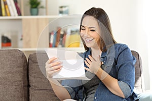 Candid woman reading hopeful news in a letter photo