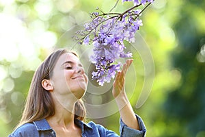 Candid woman smelling flowers in a park photo