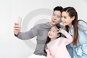 Candid of young attractive happy asian family using smartphone selfie together or video call. Social media community in asian