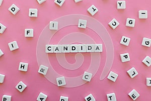 Candida word made of square letter word on pink background.