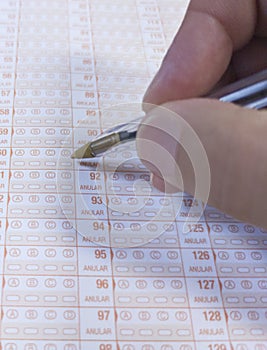 Candidate hand holds a ballpen over multiple-choice test