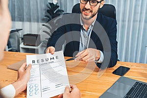 Candidate handing resume or CV over table to interviewer. Entity