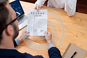 Candidate handing resume or CV over table to interviewer. Entity