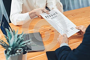 Candidate handing resume or CV over table to interviewer. Entity