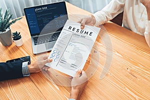 Candidate handing resume or CV over table to interviewer. Entity