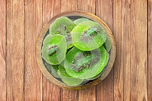 Candied fruit, dried kiwi with sugar in bowl on wooden table background, top view. organic vegetarian food