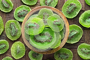 Candied fruit, dried kiwi with sugar in wooden bowl, top view