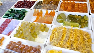 Candied fruit presented on showcase beckoning customers, appetizing sweets