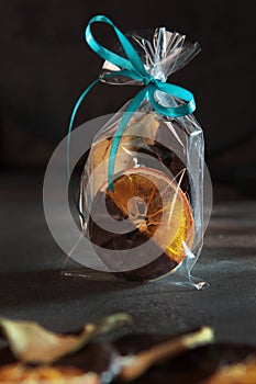 Candied orange slices with chocolate in a transparent bag. Chocolate sauce. Slices of dried orange. Sweet dessert