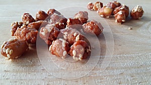 Candied peanuts on wood background.