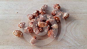 Candied peanuts on wood background.