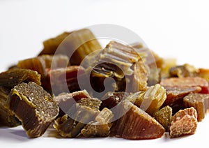 Candied rhubarb on a white background. Dry rhubarb close - up macro photography. Rheum. Dried rhubarb candied fruits