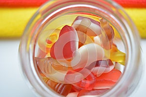 Candies jelly beans in glass bank top view background