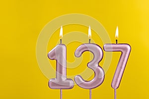 Candle 137 with flame - Birthday card on yellow luxury background