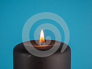 a candle against a blue background with copy space for the words