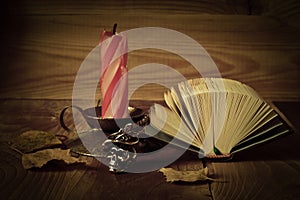 Candle and book on a wooden table