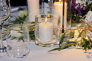 A candle is burning on the festively decorated table