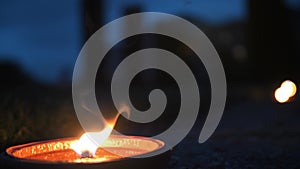 A candle burning on the ground at night in the garden park of the castle. Soft selective focus.