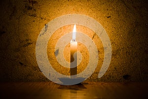 Candle burning, grungy wall background