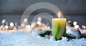 Candle burning on snow with bokeh lights