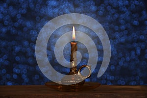 Candle burns with a bright flame in a candlestick in a dark room, the concept of magic, prayer, spiritualism, mourning