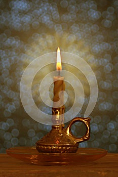 Candle burns with a bright flame in a candlestick in a dark room, the concept of magic, prayer, spiritualism, mourning