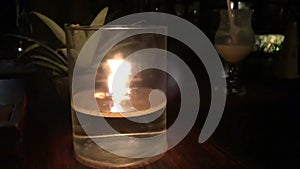 Candle burns on the table of a restaurant in a tropical resort