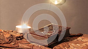 candle burns on tree bark on candle burning day with bookplate in leather binding photo