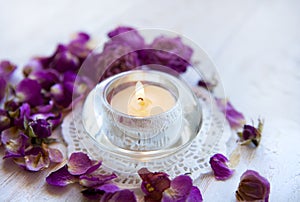 Candle in the dried rose petals . aromatherapy