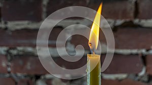 Candle flame close-up on a light red wall background. Melted Wax Candle light border design. Long Exposure