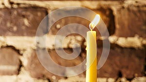 Candle flame close-up on a light red wall background. Melted Wax Candle light border design. Long Exposure