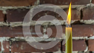 Candle flame close-up on a light red wall background. Melted Wax Candle light border design. Long Exposure