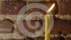 Candle flame close-up on a light red wall background. Melted Wax Candle light border design. Long Exposure.