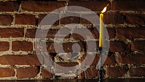 Candle flame close-up on a light red wall background. Melted Wax Candle light border design. Long Exposure