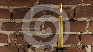 Candle flame close-up on a light red wall background. Melted Wax Candle light border design. Long Exposure