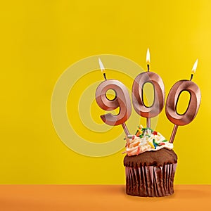 Candle with flame number 900 - Anniversary card on yellow background