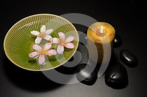 Candle and flowers bowl and black stone