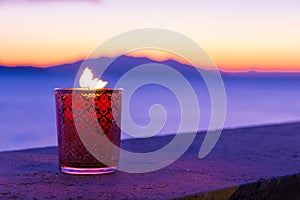 Candle glass at sunset in italy, sea and Elba island, in the background